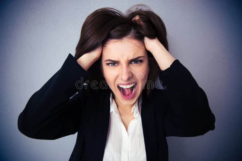 Donna di affari arrabbiata che grida sopra il fondo grigio immagine stock Donna di affari arrabbiata che grida sopra il fondo grigio immagine stock