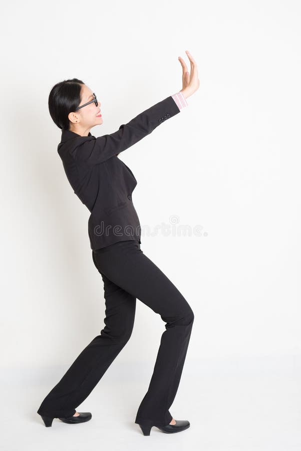 Donna di affari asiatica che solleva qualche cosa di pesante immagini stock libere da diritti Donna di affari asiatica che solleva qualche cosa di pesante immagini stock libere da diritti
