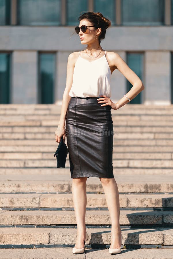Donna di affari castana alla moda nella gonna di cuoio della matita e nella s immagini stock Donna di affari castana alla moda nella gonna di cuoio della matita e nella s immagini stock
