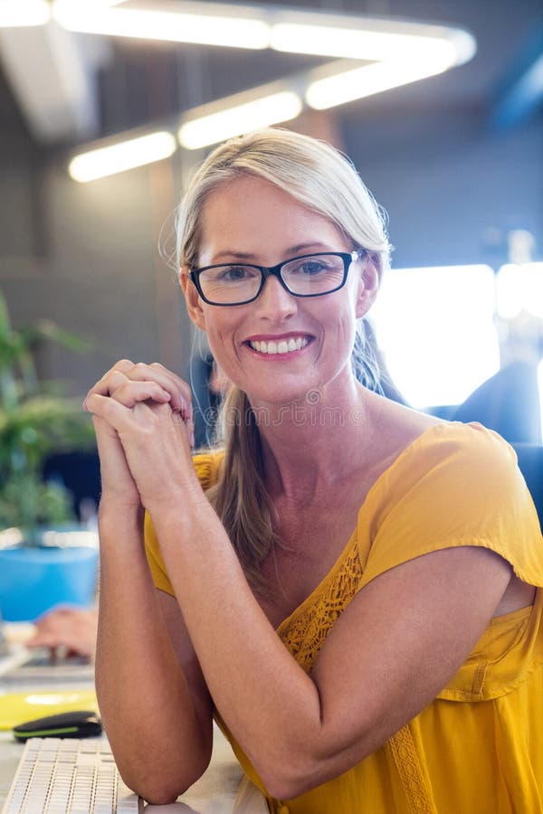 Donna di affari casuale che sorride alla macchina fotografica immagini stock libere da diritti Donna di affari casuale che sorride alla macchina fotografica immagini stock libere da diritti