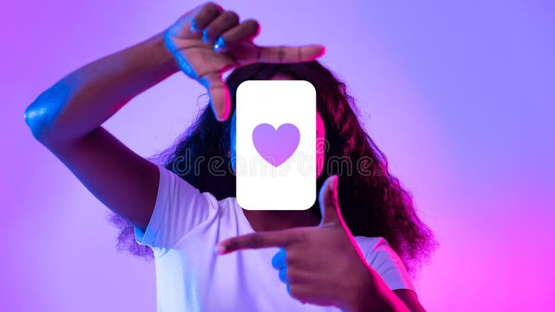 Black woman capturing heart like symbol making picture frame with fingers, pretending taking photo on phone and posting it in social media app in purple neon light. Collage. Black woman capturing heart like symbol making picture frame with fingers, pretending taking photo on phone and posting it in social media app in purple neon light. Collage