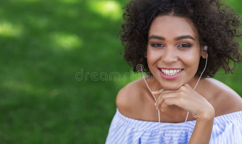 Donna di colore emozionante che ascolta la musica all'aperto fotografie stock libere da diritti Donna di colore emozionante che ascolta la musica all'aperto fotografie stock libere da diritti