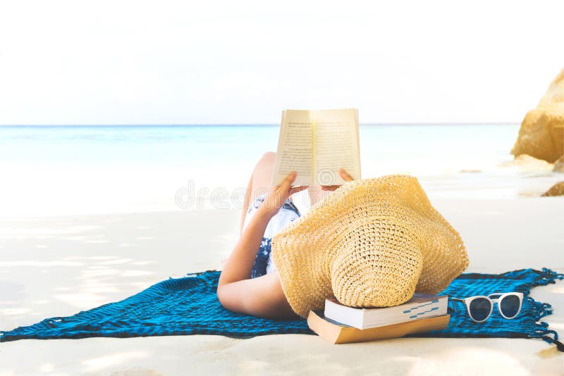 Donna di festa della spiaggia di estate che legge un libro sulla spiaggia a tempo il tempo libero fotografia stock Donna di festa della spiaggia di estate che legge un libro sulla spiaggia a tempo il tempo libero fotografia stock