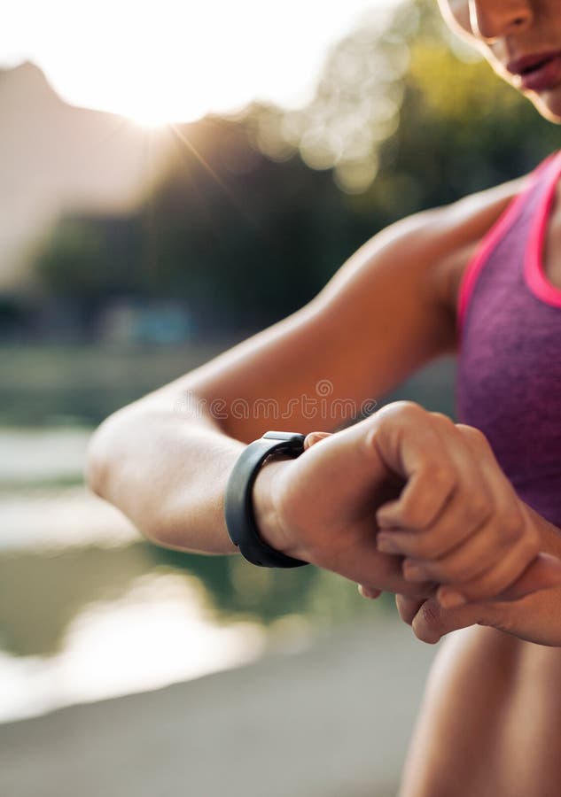 Donna di forma fisica che controlla la sua prestazione su smartwatch fotografia stock Donna di forma fisica che controlla la sua prestazione su smartwatch fotografia stock