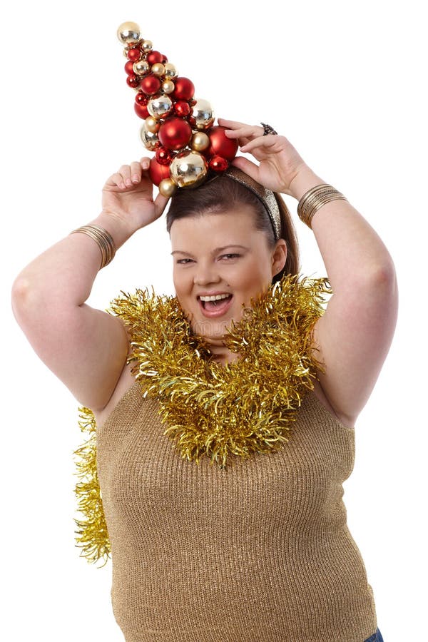 Donna di peso eccessivo con piccolo sorridere dell'albero di Natale fotografie stock libere da diritti Donna di peso eccessivo con piccolo sorridere dell'albero di Natale fotografie stock libere da diritti