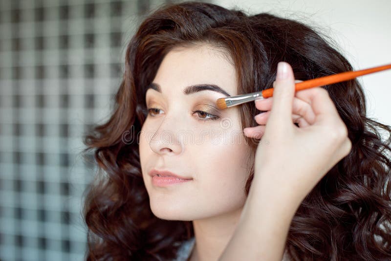 Donna di trucco dell'occhio che applica la polvere dell'ombretto Il truccatore che fa il professionista compone della giovane don fotografie stock Donna di trucco dell'occhio che applica la polvere dell'ombretto Il truccatore che fa il professionista compone della giovane don fotografie stock
