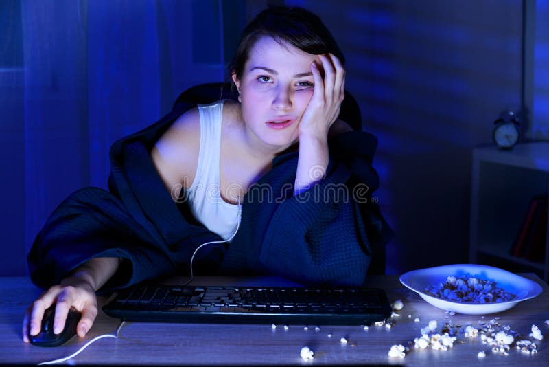 Young sleepy addicted woman using computer at night. Young sleepy addicted woman using computer at night