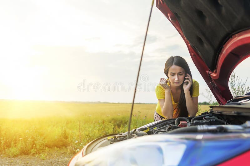 Donna ed automobile rotta fotografia stock Donna ed automobile rotta fotografia stock
