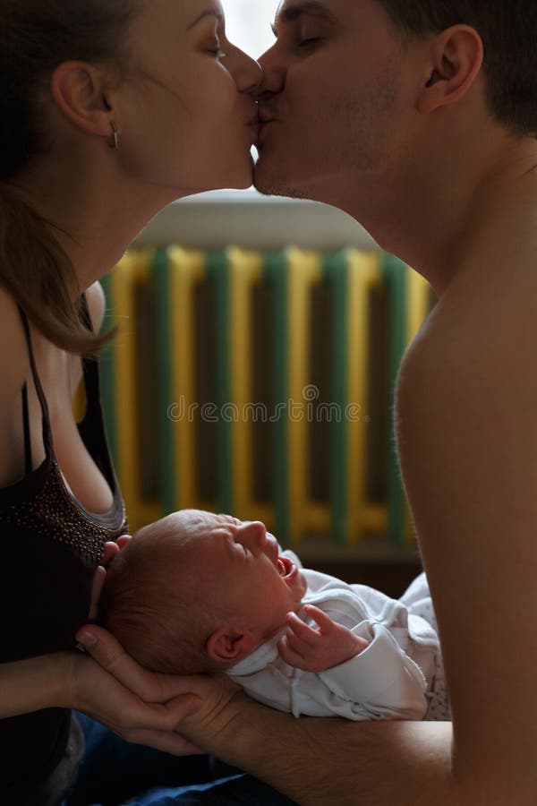 Donna ed uomo che tengono sulle mani un neonato Mamma, papà e bambino Bacio dei genitori Grida e grida del ragazzo Vita familiare fotografia stock libera da diritti Donna ed uomo che tengono sulle mani un neonato Mamma, papà e bambino Bacio dei genitori Grida e grida del ragazzo Vita familiare fotografia stock libera da diritti
