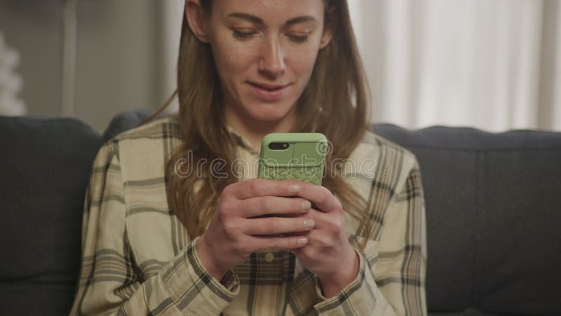 Donna emotiva sorridente che scrive sullo smartphone video d archivio