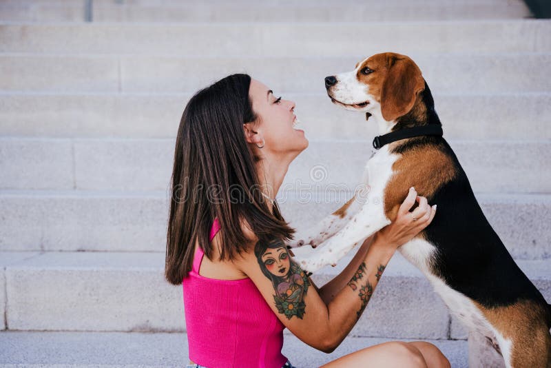 Happy woman outdoors with her beagle dog. Family and lifestyle concept. Happy woman outdoors with her beagle dog. Family and lifestyle concept