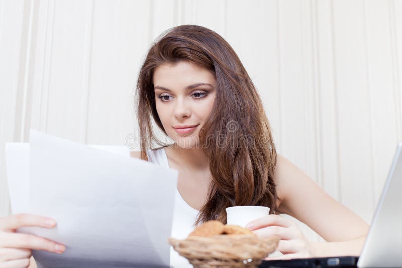 Donna felice che gode del tè e dei biscotti immagine stock