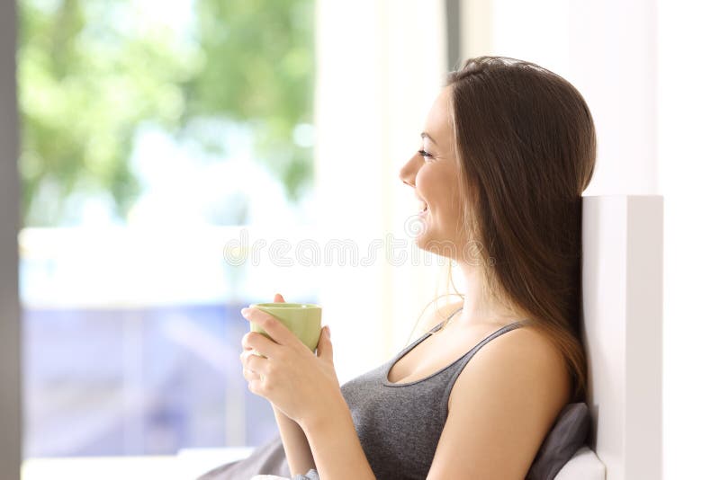 Donna felice che mangia prima colazione sul letto immagine stock libera da diritti Donna felice che mangia prima colazione sul letto immagine stock libera da diritti