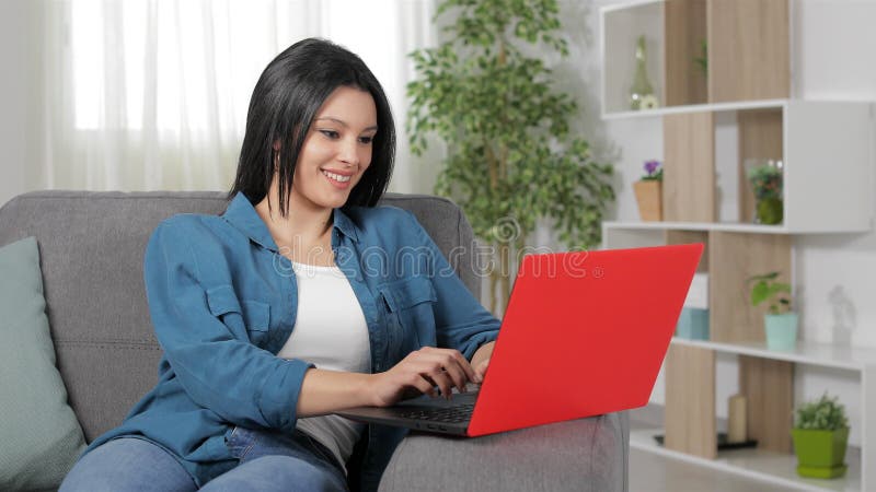 Donna felice che scrive sul computer portatile a casa archivi video