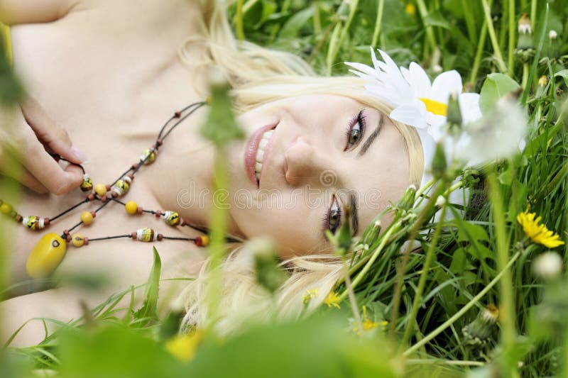 Donna felice che si trova nel campo con i camomiles. immagini stock libere da diritti Donna felice che si trova nel campo con i camomiles. immagini stock libere da diritti