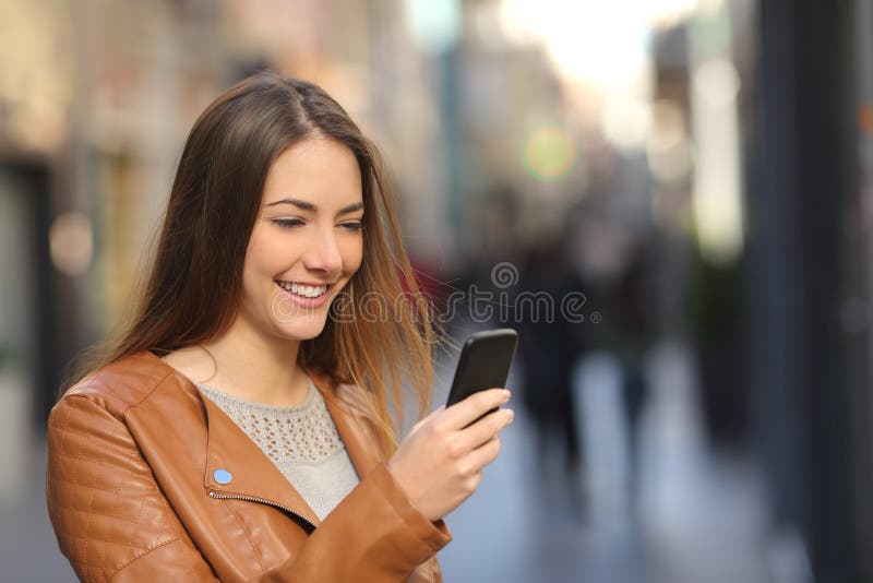 Donna felice che utilizza uno Smart Phone nella via fotografie stock
