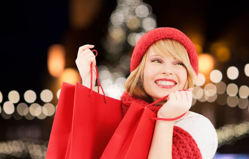 Donna felice con i sacchetti della spesa sopra l'albero di Natale fotografia stock libera da diritti