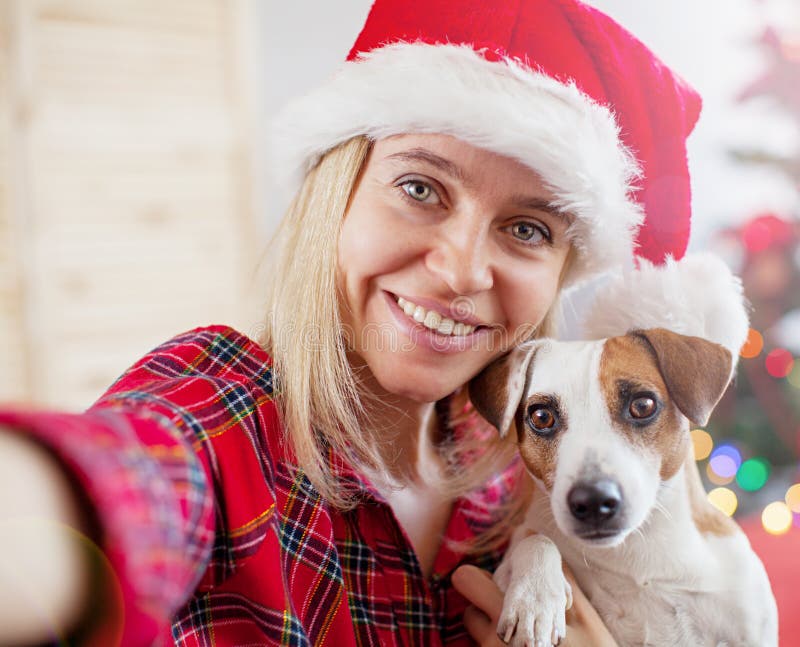 Donna felice con il cane prendere un selfie nella decorazione di natale immagini stock libere da diritti Donna felice con il cane prendere un selfie nella decorazione di natale immagini stock libere da diritti
