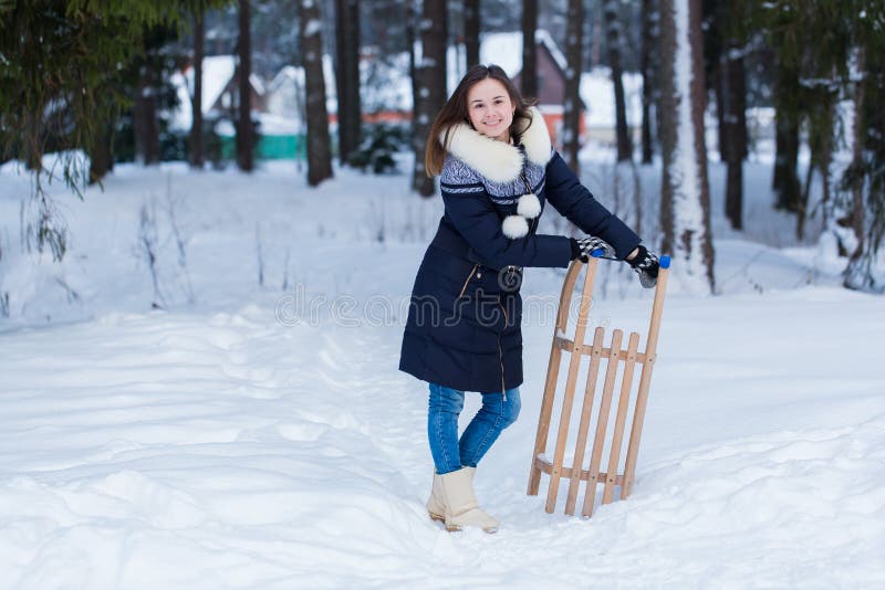 Donna felice con le slitte nel giorno di inverno fotografia stock Donna felice con le slitte nel giorno di inverno fotografia stock