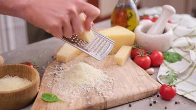 Donna Gratta Un Pezzo Di Formaggio Di Parmigiano Su Una Grattugia in Cucina  Archivi Video - Video di bordo, squisito: 258093425