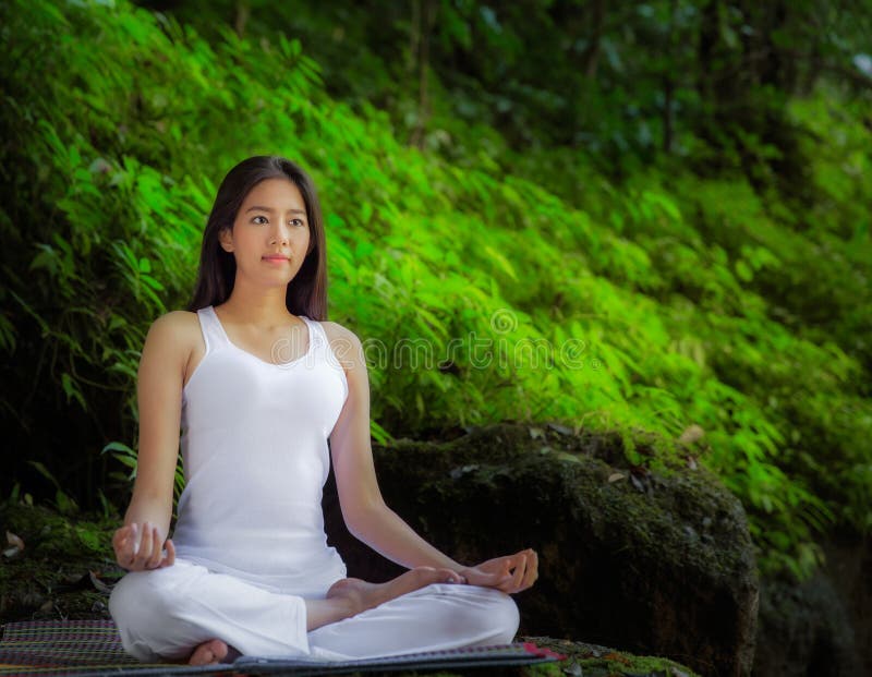 Donna graziosa asiatica che fa gli esercizi di yoga fotografia stock libera da diritti Donna graziosa asiatica che fa gli esercizi di yoga fotografia stock libera da diritti