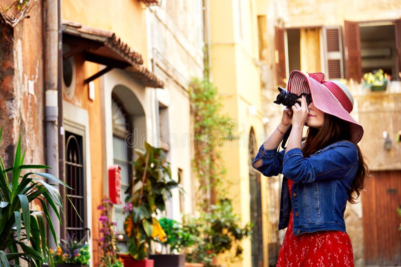 Donna graziosa in cappello che tende con la macchina fotografica a Trastevere a Roma, Italia immagine stock libera da diritti Donna graziosa in cappello che tende con la macchina fotografica a Trastevere a Roma, Italia immagine stock libera da diritti
