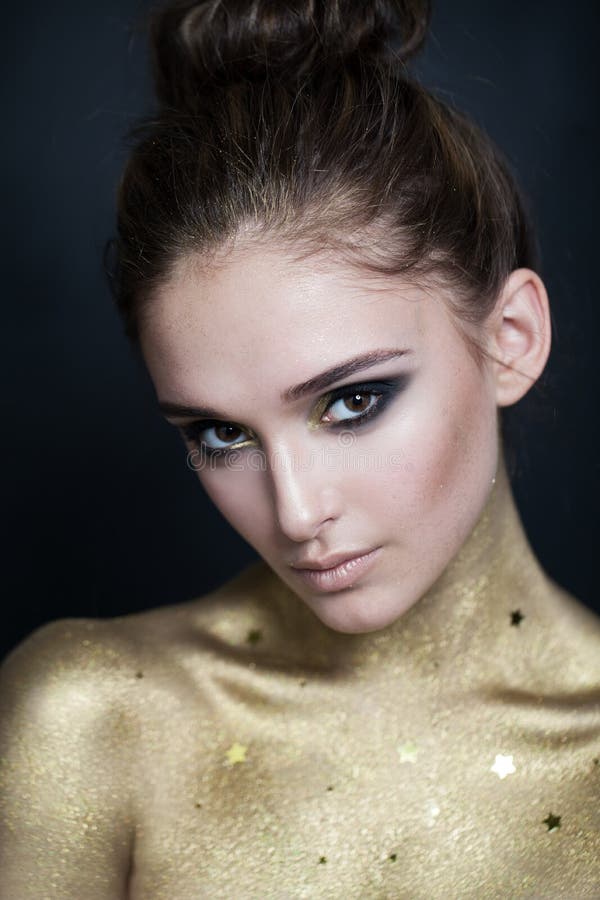 Donna graziosa con pelle dorata e Smokey Eyes Makeup fotografie stock libere da diritti Donna graziosa con pelle dorata e Smokey Eyes Makeup fotografie stock libere da diritti