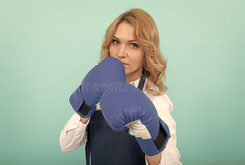 Donna in grembiule che colpisce guanti da boxe immagine stock