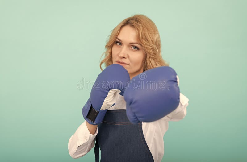 Donna in grembiule che punge pugile guanti da boxe immagine stock