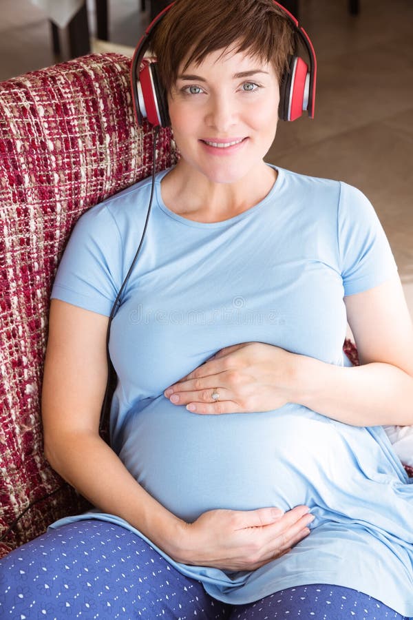 Donna incinta che ascolta la musica fotografia stock Donna incinta che ascolta la musica fotografia stock