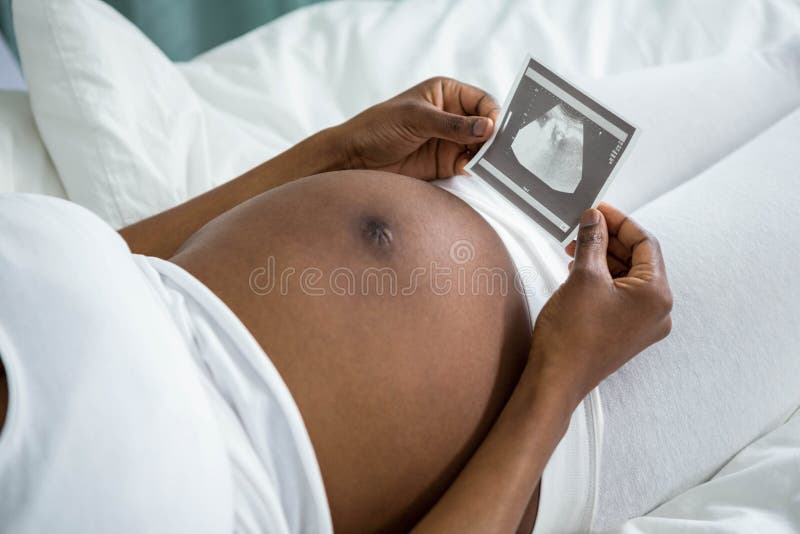 Donna incinta che esamina l'immagine di ultrasuono immagini stock Donna incinta che esamina l'immagine di ultrasuono immagini stock