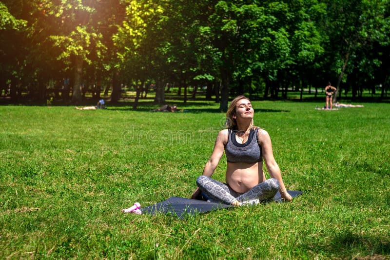 Donna incinta che fa gli esercizi nel parco Gravidanza Stile di vita sano fotografia stock Donna incinta che fa gli esercizi nel parco Gravidanza Stile di vita sano fotografia stock