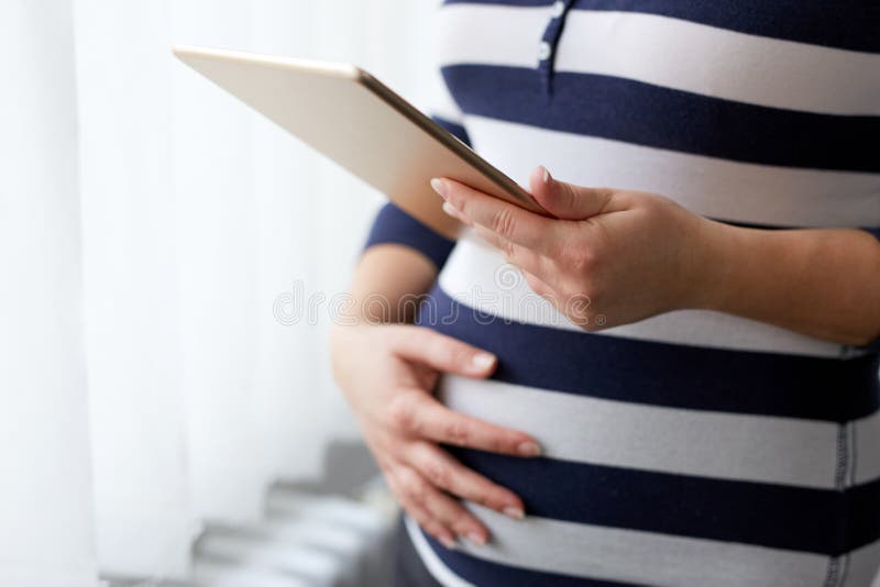 Donna incinta che per mezzo del computer della compressa