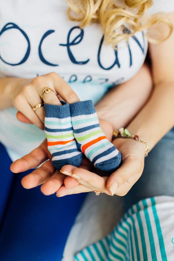 Donna incinta che tiene le piccole scarpe di bambino immagini stock libere da diritti Donna incinta che tiene le piccole scarpe di bambino immagini stock libere da diritti
