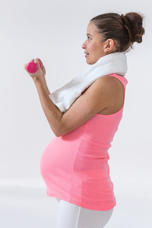 Donna incinta che usando i handweights fotografia stock libera da diritti Donna incinta che usando i handweights fotografia stock libera da diritti
