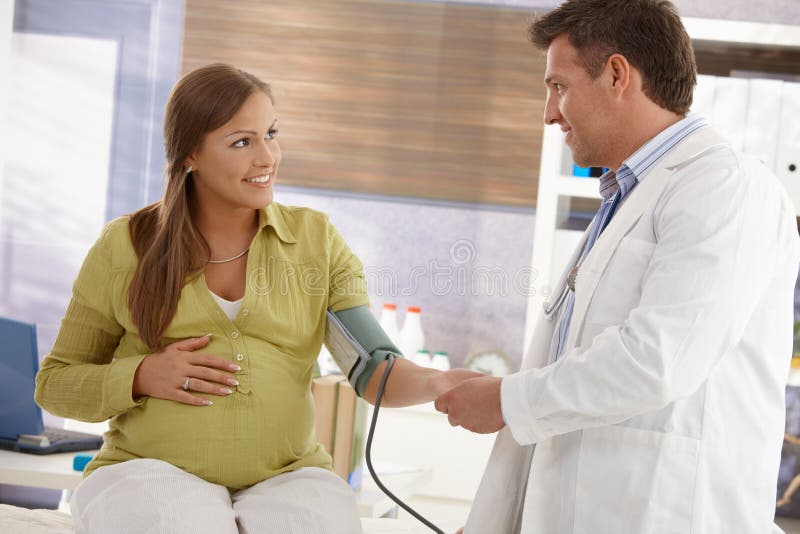 Donna incinta che vede medico fotografia stock libera da diritti Donna incinta che vede medico fotografia stock libera da diritti