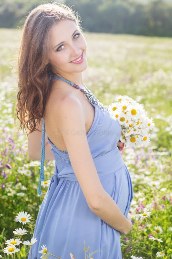 Donna incinta con il mazzo dei fiori della margherita fotografie stock libere da diritti Donna incinta con il mazzo dei fiori della margherita fotografie stock libere da diritti