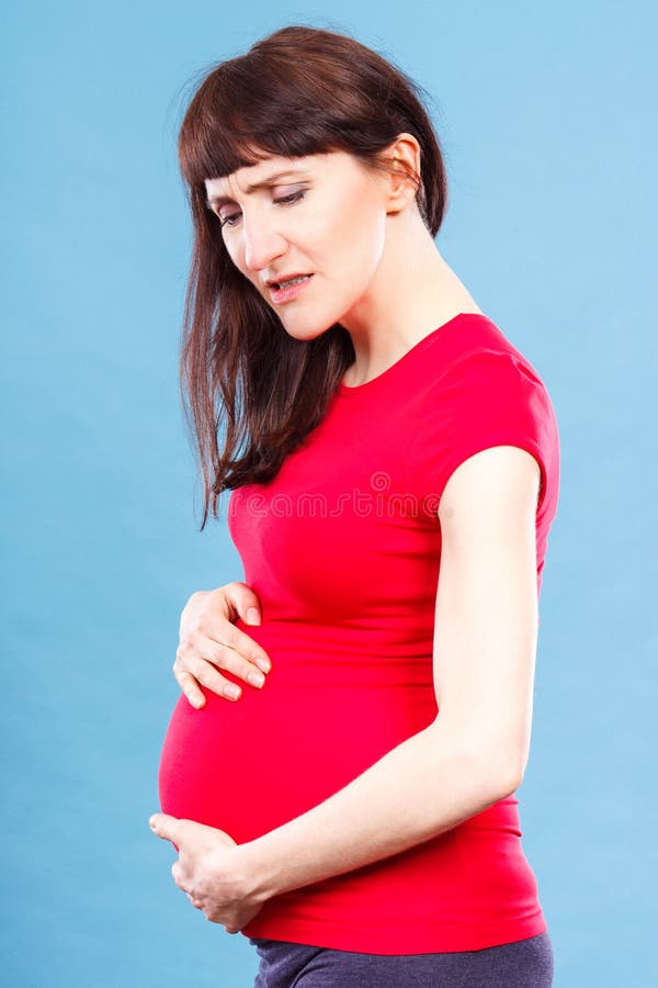 Donna incinta triste con mal di stomaco che tocca la sua pancia, i dolori nella gravidanza e rischio di aborto fotografie stock libere da diritti Donna incinta triste con mal di stomaco che tocca la sua pancia, i dolori nella gravidanza e rischio di aborto fotografie stock libere da diritti