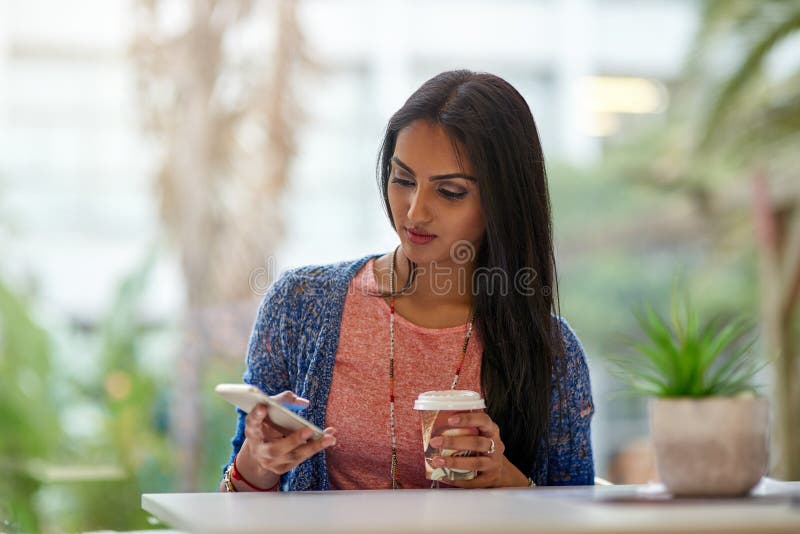Donna indiana bar e smartphone con caffè su break social media e networking come studentessa universitaria immagini stock