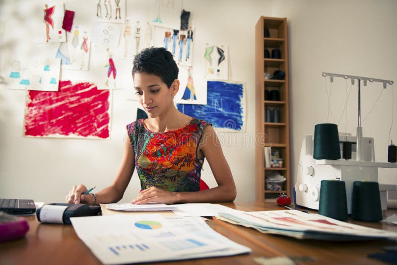 Donna ispanica che fa preventivo nell'atelier di modo fotografia stock libera da diritti Donna ispanica che fa preventivo nell'atelier di modo fotografia stock libera da diritti