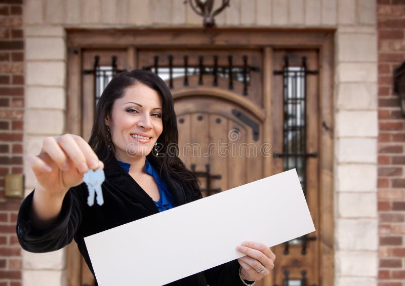 Donna ispanica con cartelli bianchi e chiavi davanti alla casa fotografie stock libere da diritti