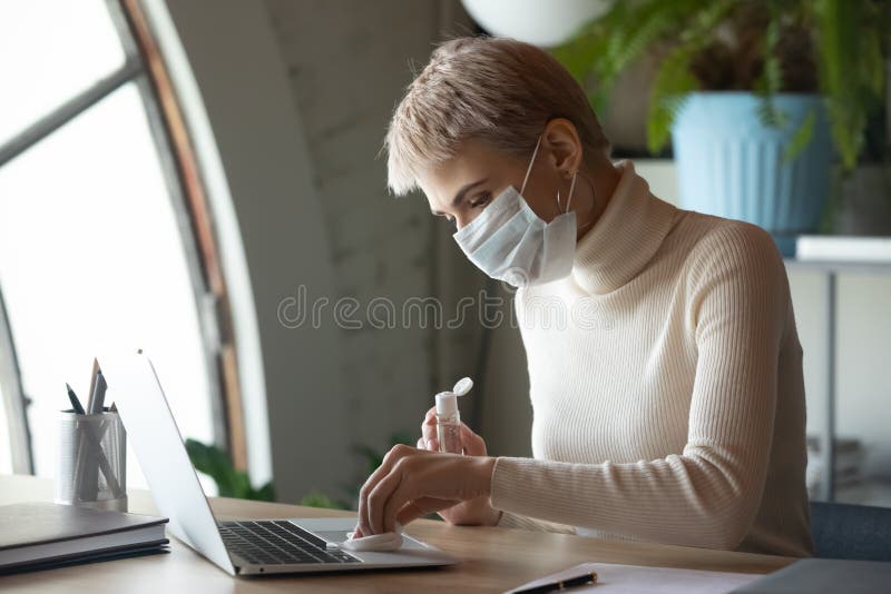 Donna lavoratrice disinfezione sul posto di lavoro con disinfettante