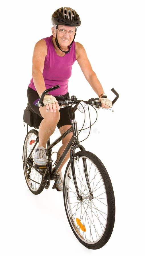 Donna maggiore adatta sorridente che guida una bicicletta immagini stock libere da diritti