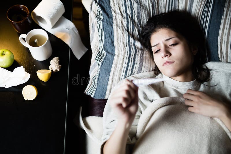 Donna malata a letto, chiamando nel malato, giorno libero da lavoro Termometro per controllare temperatura per vedere se c'è febb