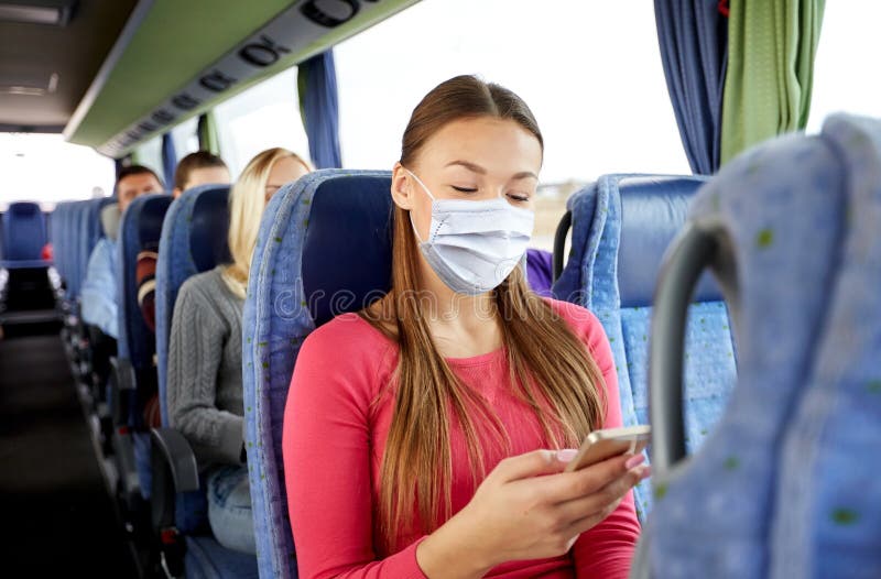 Donna mascherata con smartphone in autobus da viaggio