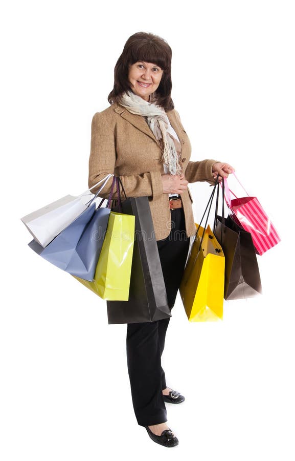 Donna matura felice che cammina con i suoi acquisti di acquisto immagine stock libera da diritti Donna matura felice che cammina con i suoi acquisti di acquisto immagine stock libera da diritti