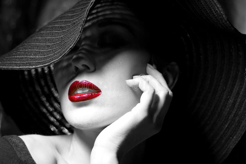 Portrait of mysterious beautiful young woman with wonderful skin texture in black hat. Trendy glamorous fashion makeup. Sensual red lips. Black and white image. Art photo. Portrait of mysterious beautiful young woman with wonderful skin texture in black hat. Trendy glamorous fashion makeup. Sensual red lips. Black and white image. Art photo