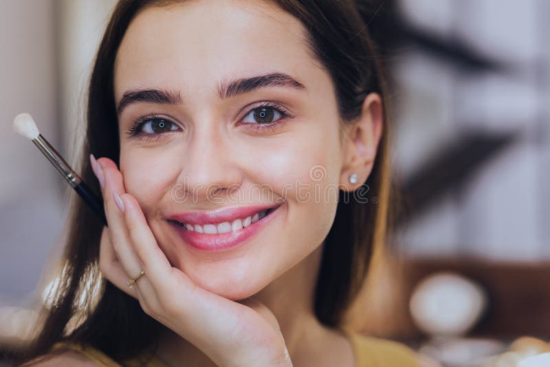 Donna molto bella che ritiene piacevole mentre esaminando specchio fotografie stock libere da diritti Donna molto bella che ritiene piacevole mentre esaminando specchio fotografie stock libere da diritti