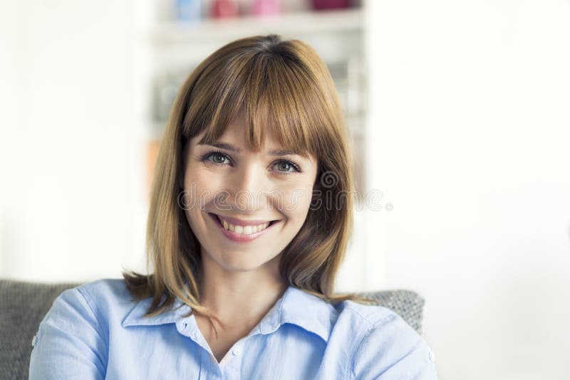 Donna naturale di trenta anni messa nella casa moderna sguardo della macchina fotografica fotografia stock Donna naturale di trenta anni messa nella casa moderna sguardo della macchina fotografica fotografia stock