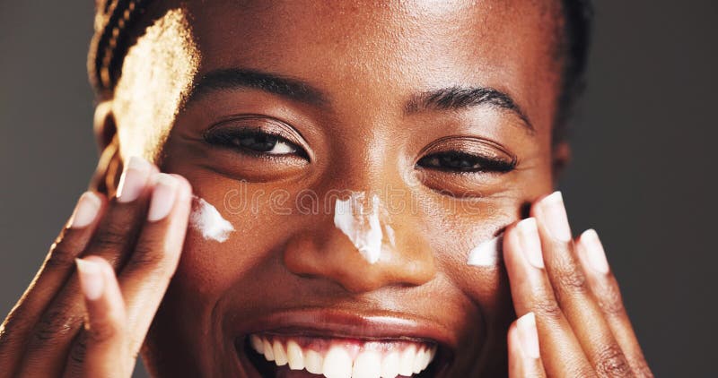 Donna nera felice e ritratto con crema per il viso in studio per la pelle su sfondo grigio. Closure femmina o fotografie stock libere da diritti
